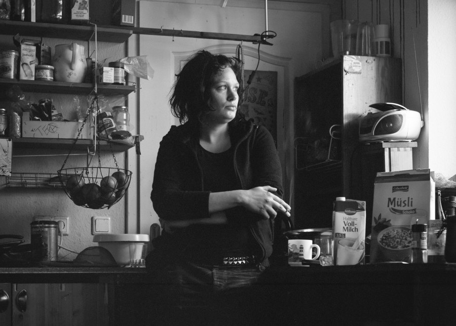 a woman is standing in the kitchen and smoking